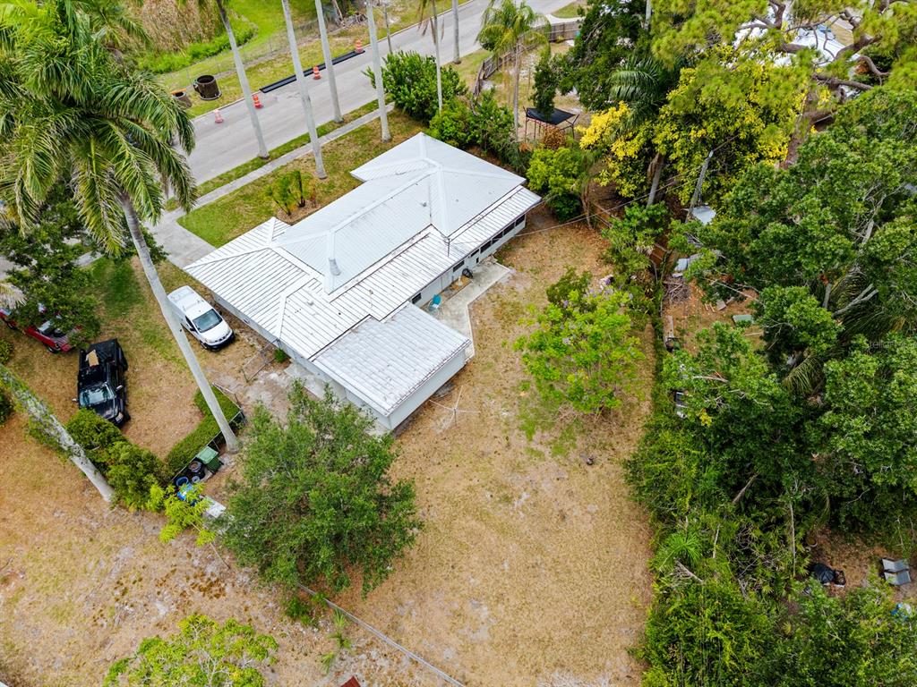 An aerial view shows a single-story house with a metal roof and a large backyard — 2415 2ND AVENUE E, BRADENTON, FL