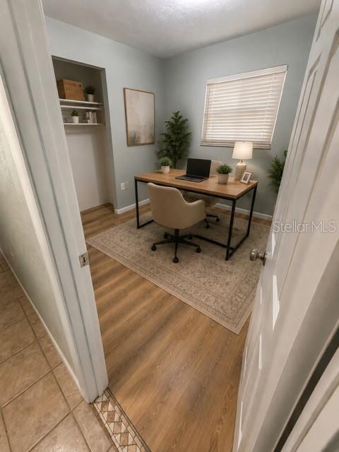 A home office features a wooden desk, an upholstered chair, and a rug on wood flooring — 2161 NE 38 STREET, OCALA, FL