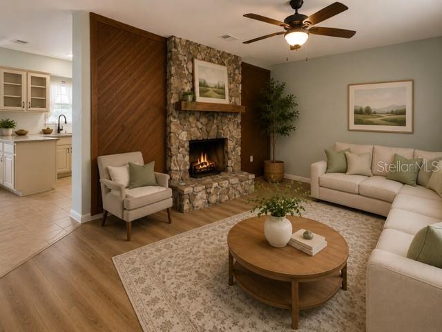 A living room features a stone fireplace, wood paneling, a ceiling fan, and neutral furniture — 2161 NE 38 STREET, OCALA, FL