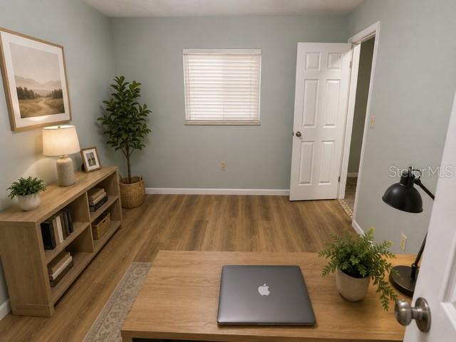 A home office features a wooden desk with a laptop, shelving, and light-colored walls — 2161 NE 38 STREET, OCALA, FL