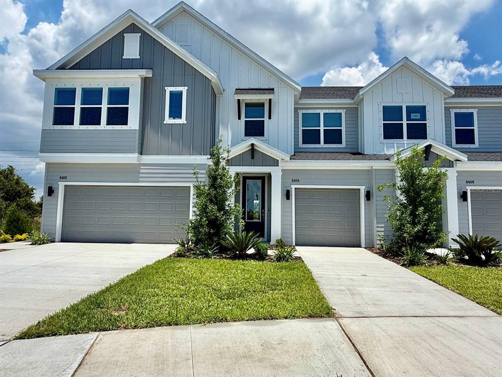 A multi-unit residential building features gray siding, white trim, and attached garages — 6404 JENSEN VIEW AVENUE, APOLLO BEACH, FL