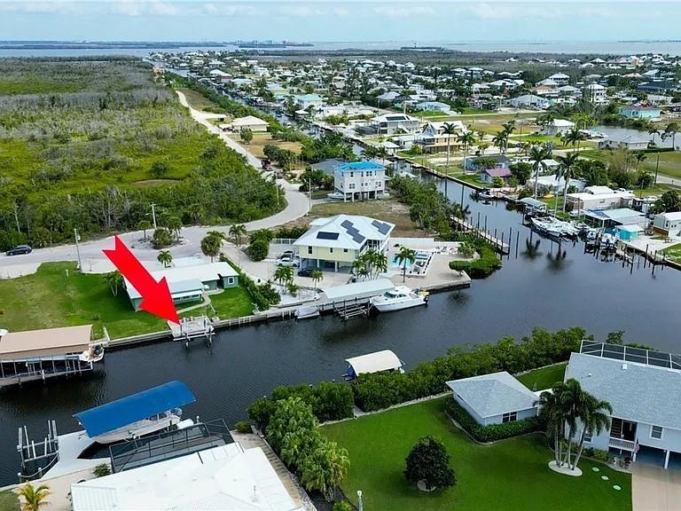 An aerial view shows a waterfront home with a boat dock and canal access — 2891 CUSSELL DRIVE, ST JAMES CITY, FL