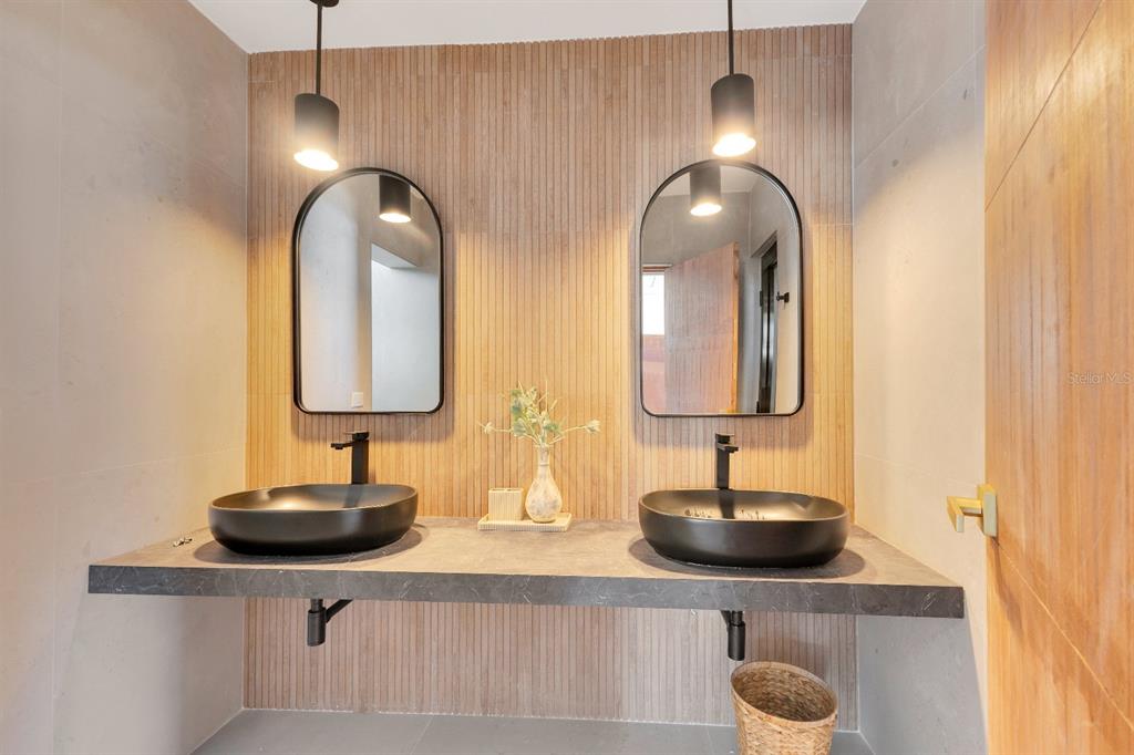A modern bathroom features a floating stone vanity with two black vessel sinks and mirrors — 7 CALLE ROSA UNIT PH, CAROLINA, PR