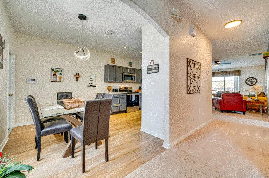 A dining area with a glass table and gray chairs opens into a kitchen — 136 SUNSET VIEW DRIVE, DAVENPORT, FL
