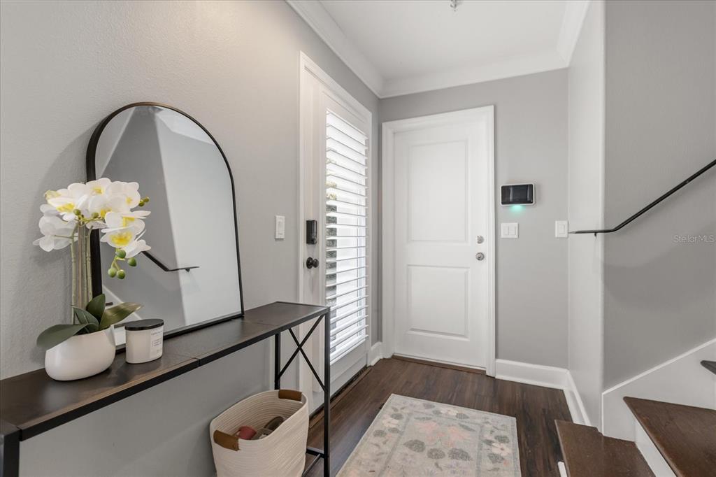 An entryway features a console table with a mirror, a white door, and stairs — 2419 KILGORE STREET, ORLANDO, FL
