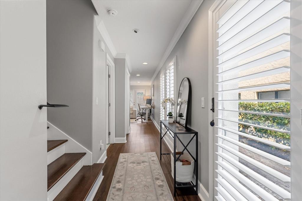 A hallway with hardwood floors, a staircase, a console table, and a view of an office — 2419 KILGORE STREET, ORLANDO, FL