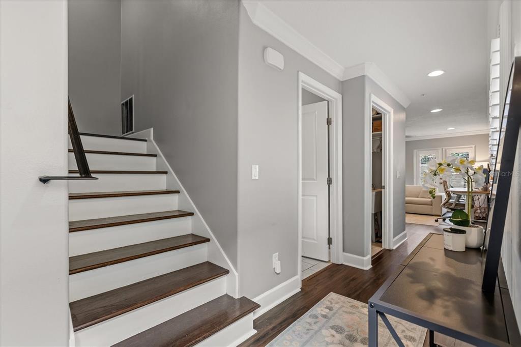 A staircase with dark wood treads and white risers leads up beside a hallway — 2419 KILGORE STREET, ORLANDO, FL