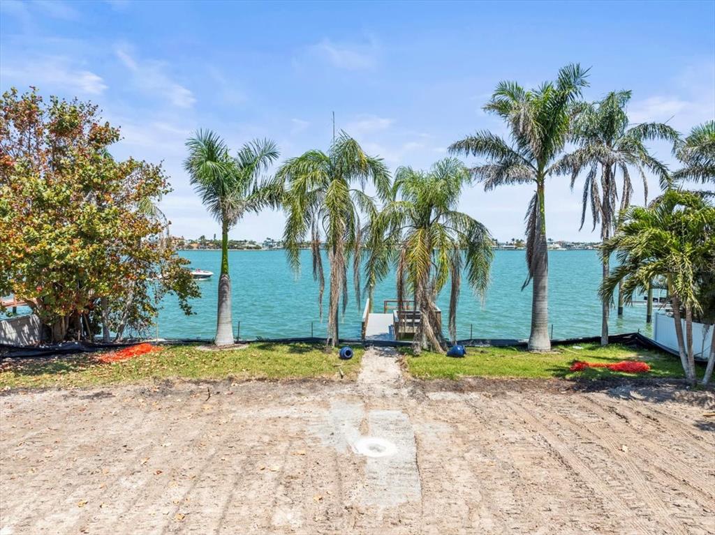 A waterfront lot with palm trees, a small wooden dock, and a view of water — 6 PARADISE LANE, TREASURE ISLAND, FL