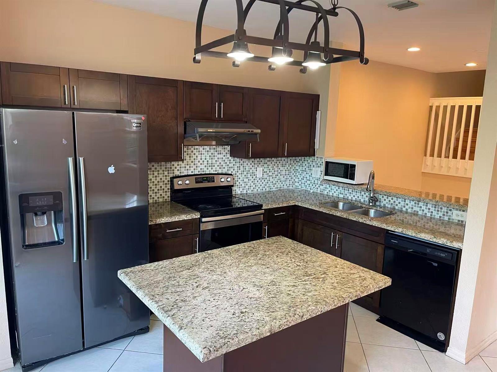 A kitchen with dark wood cabinets, granite countertops, a center island, and stainless steel appliances — 4061 NW 91st Terrace, Sunrise FL 33351, SUNRISE, FL