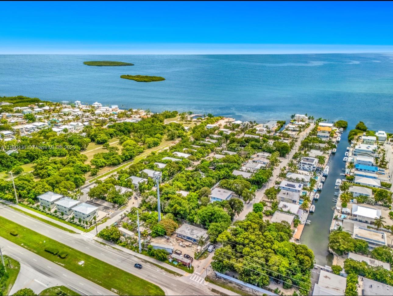 An aerial view shows a coastal neighborhood with houses, a canal, and a cell tower — 1032 Snapper Ln, Key Largo FL 33037, KEY LARGO, FL
