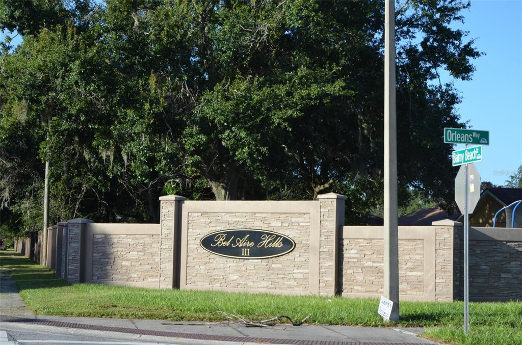 A stone and stucco entrance wall for Bel Aire Hills III stands near street signs — 2887 N BERMUDA AVENUE, APOPKA, FL