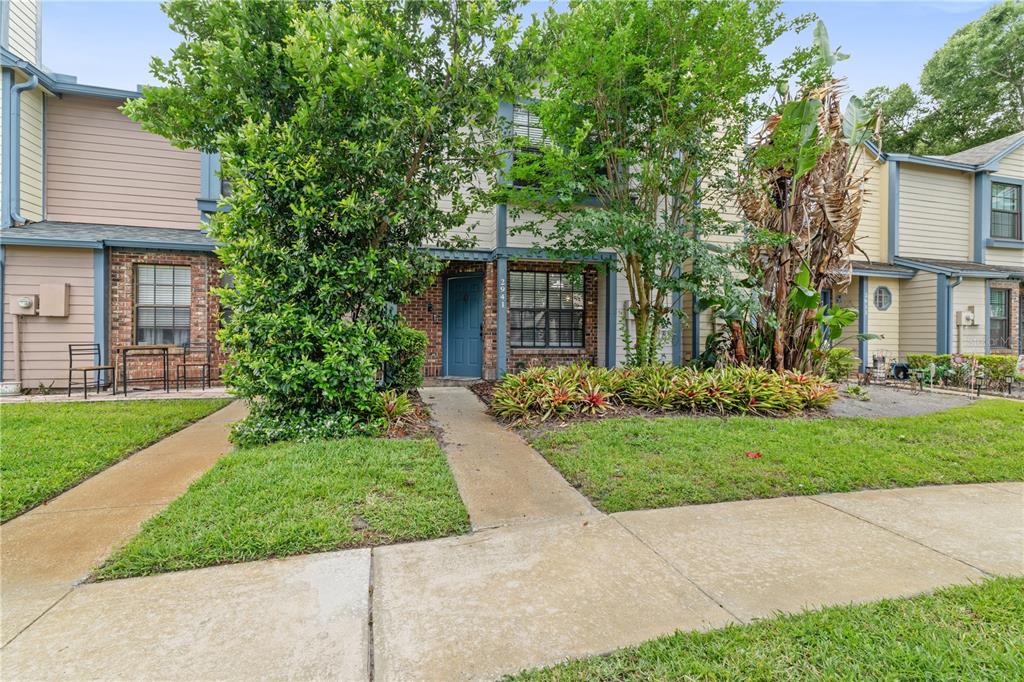 A two-story townhouse with a blue front door, brick facade, and front yard landscaping — 2941 LOWELL COURT, CASSELBERRY, FL