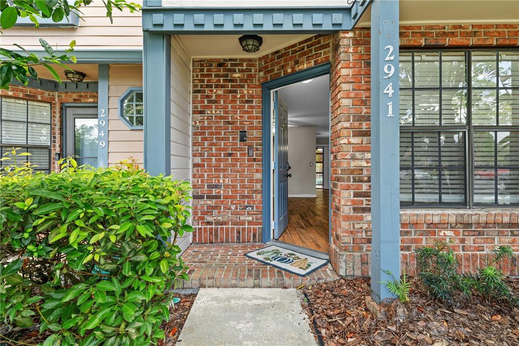 The exterior view shows a brick entryway with a blue door and two house numbers — 2941 LOWELL COURT, CASSELBERRY, FL
