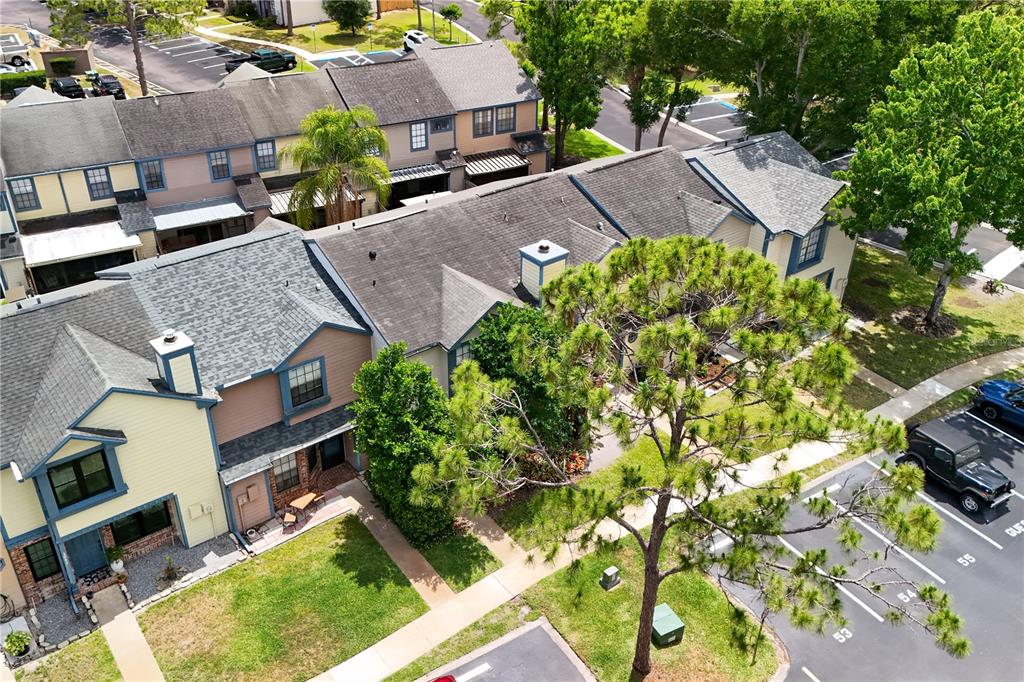 An aerial view shows a row of multi-story townhouses with parking spaces and trees — 2941 LOWELL COURT, CASSELBERRY, FL