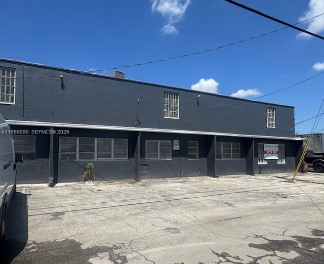 A dark gray, two-story commercial building with multiple windows and a paved parking lot — 7130 NW 35th Ave, Miami FL 33147, MIAMI, FL