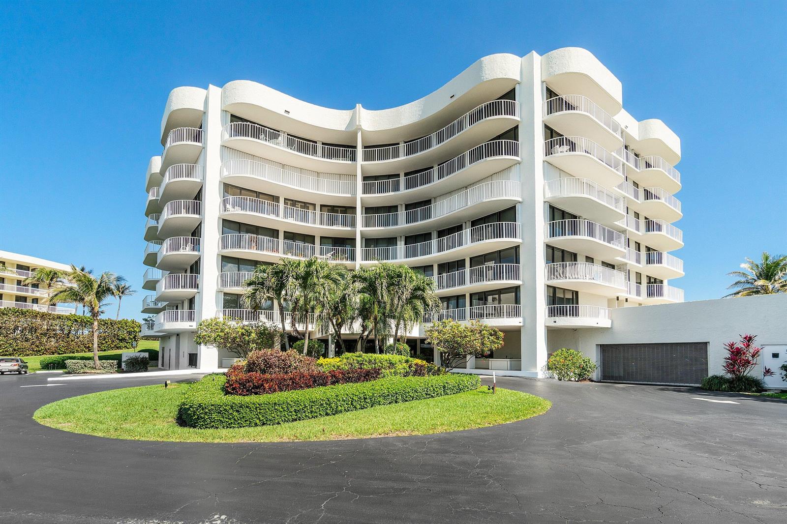 A multi-story white residential building features curved balconies and a circular driveway with landscaping — 3360 S Ocean Boulevard, Palm Beach FL 33480, PALM BEACH, FL