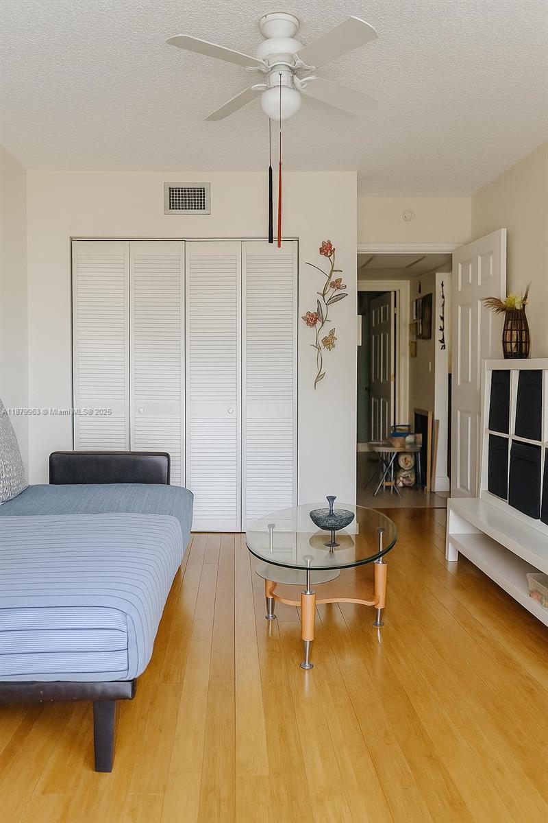 A living room features a blue futon, a glass coffee table, and white closet doors — 13781 SW 66th St # 221B, Miami FL 33183, MIAMI, FL