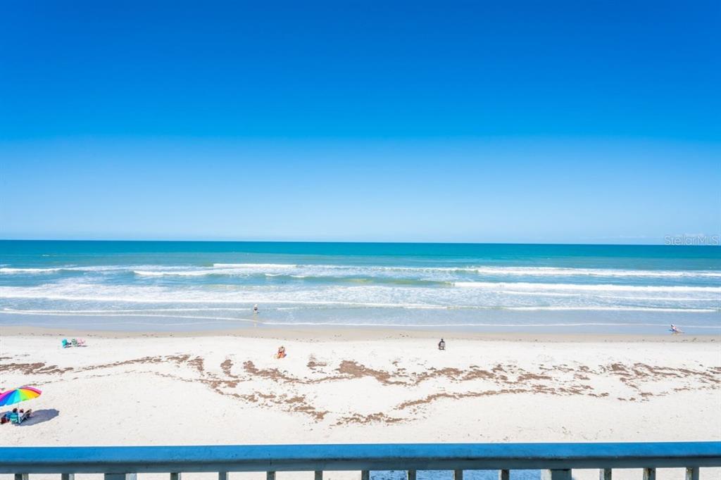 A view of a sandy beach and the ocean from a balcony — 5203 S ATLANTIC AVENUE UNIT 314B, NEW SMYRNA BEACH, FL