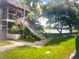 An exterior view of a two-story apartment building with stairs leading to an upper balcony — 3652 NW 95th Ter # 7K, Sunrise FL 33351, SUNRISE, FL