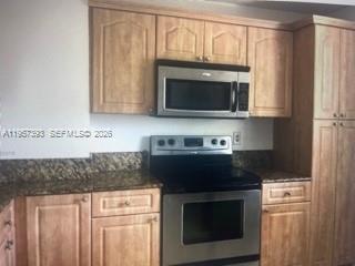 A kitchen features light wood cabinets, stainless steel appliances, and dark granite countertops — 3652 NW 95th Ter # 7K, Sunrise FL 33351, SUNRISE, FL