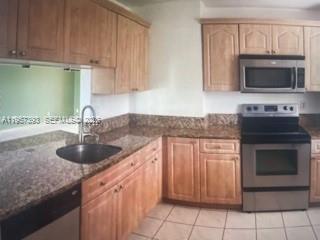 A kitchen with light wood cabinets, granite countertops, and stainless steel appliances — 3652 NW 95th Ter # 7K, Sunrise FL 33351, SUNRISE, FL