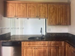 A kitchen features wood cabinets, dark granite countertops, and a stainless steel dishwasher — 3652 NW 95th Ter # 7K, Sunrise FL 33351, SUNRISE, FL