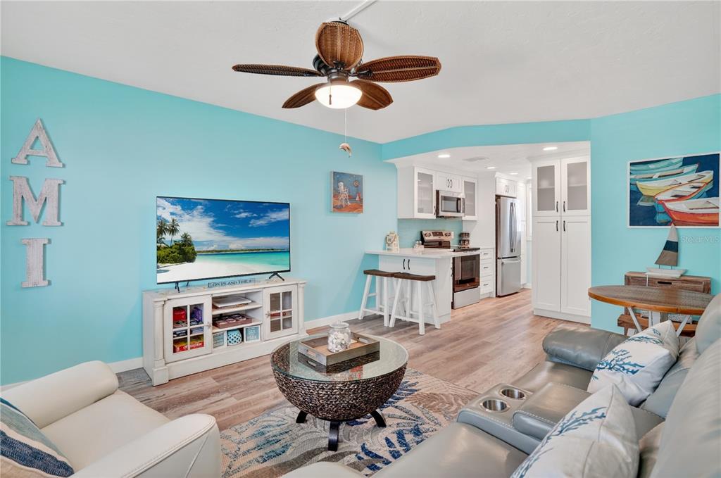 A living room with light blue walls, a ceiling fan, and an open kitchen area — 117 7TH STREET N UNIT 2, BRADENTON BEACH, FL