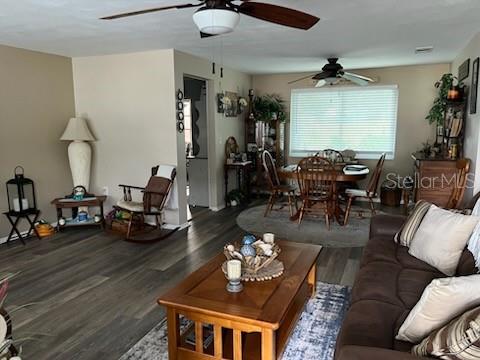 A living room and dining area feature wood-look flooring, ceiling fans, and neutral walls — 3419 PALOMA DRIVE, HOLIDAY, FL
