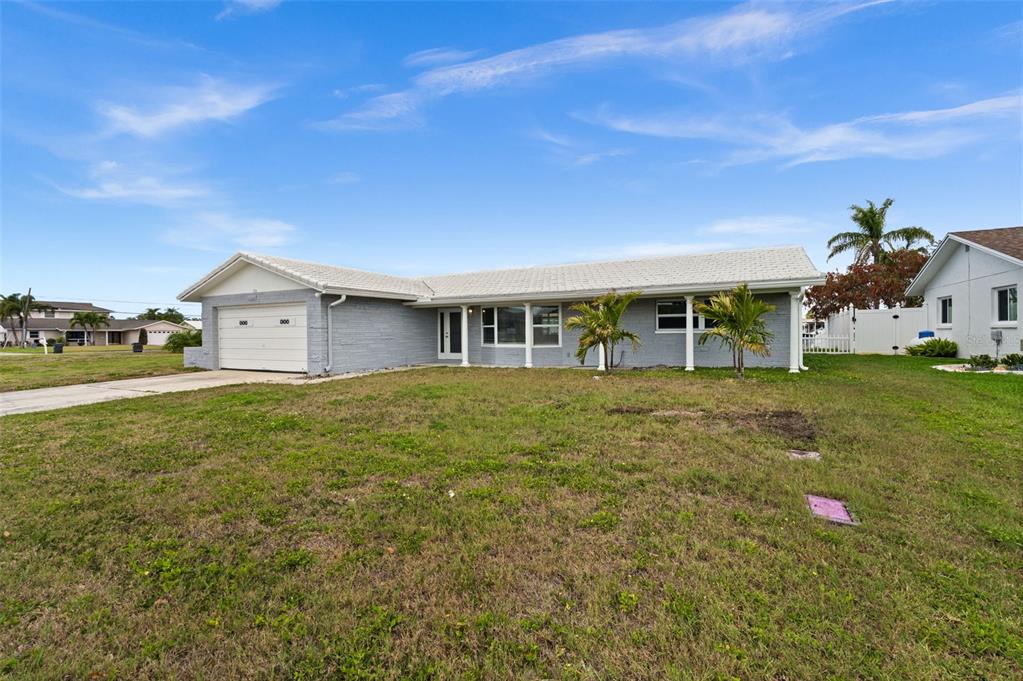 A single-story gray house with a white roof and a two-car garage — 710 116TH AVENUE, TREASURE ISLAND, FL