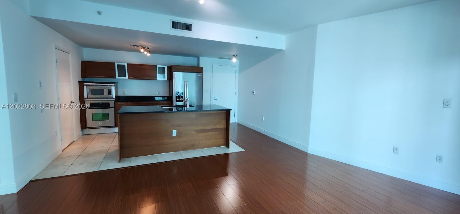 This kitchen features dark wood cabinets, stainless steel appliances, and a central island — 1900 N Bayshore Dr # 3717, Miami FL 33132, MIAMI, FL
