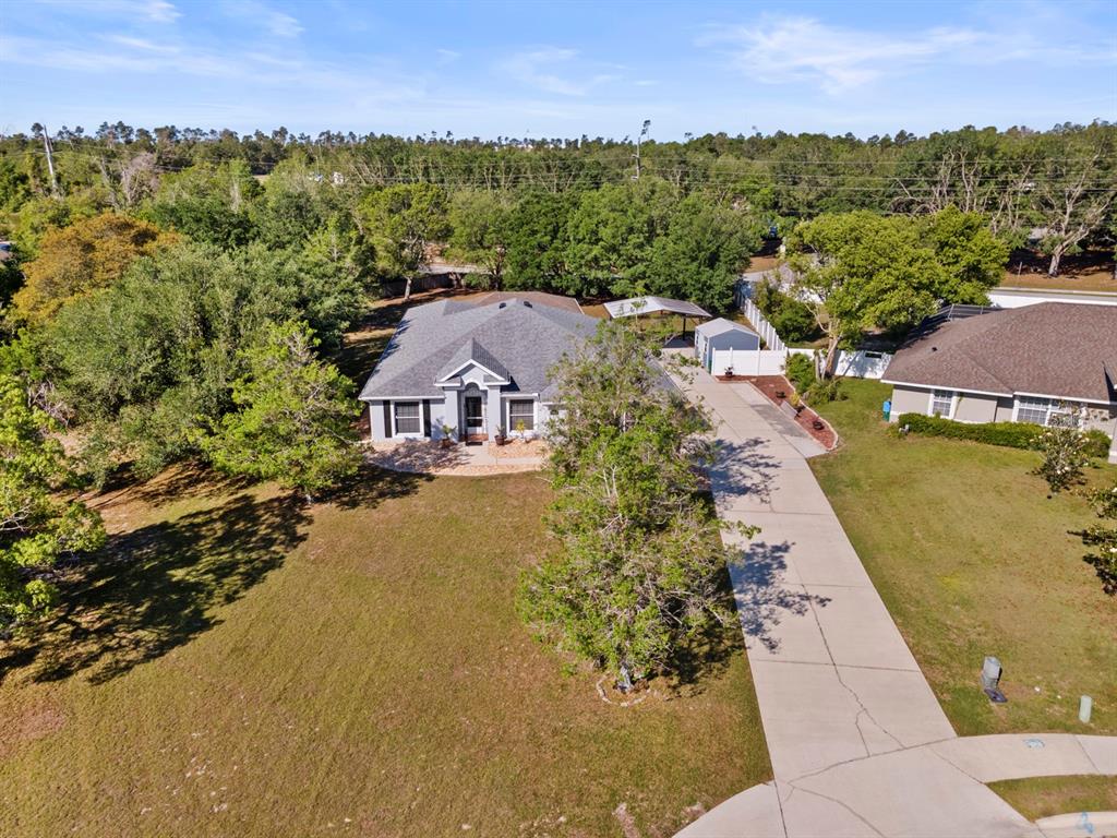 An aerial view of a single-story house with a driveway and a detached shed — 900 BLANEY COURT, DELTONA, FL