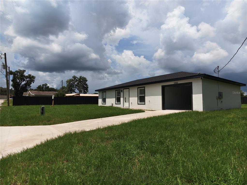 A single-story house with a white exterior, dark trim, and an attached garage — 3400 SE 11TH AVENUE, OCALA, FL
