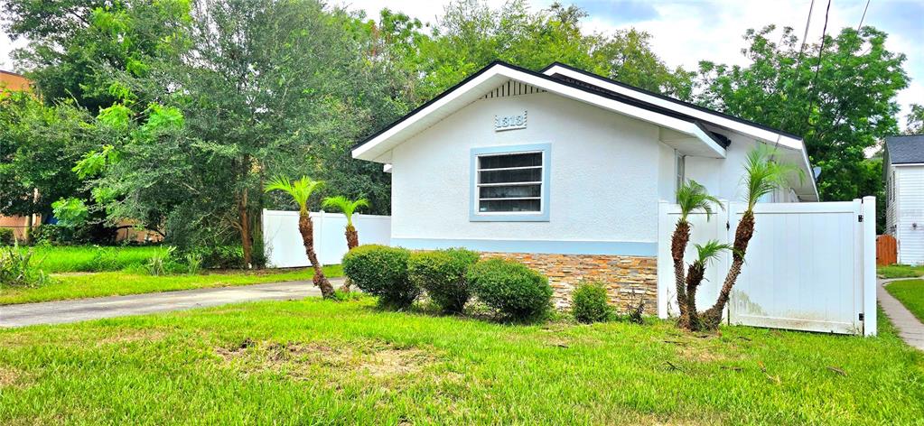 A room with light wood-look flooring, a brick fireplace, and an electric fireplace insert — 1313 CATHERINE STREET, ORLANDO, FL