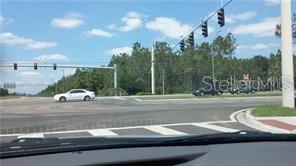 A view from a vehicle looking at a paved intersection with traffic lights and trees — INTERNATIONAL DRIVE, ORLANDO, FL