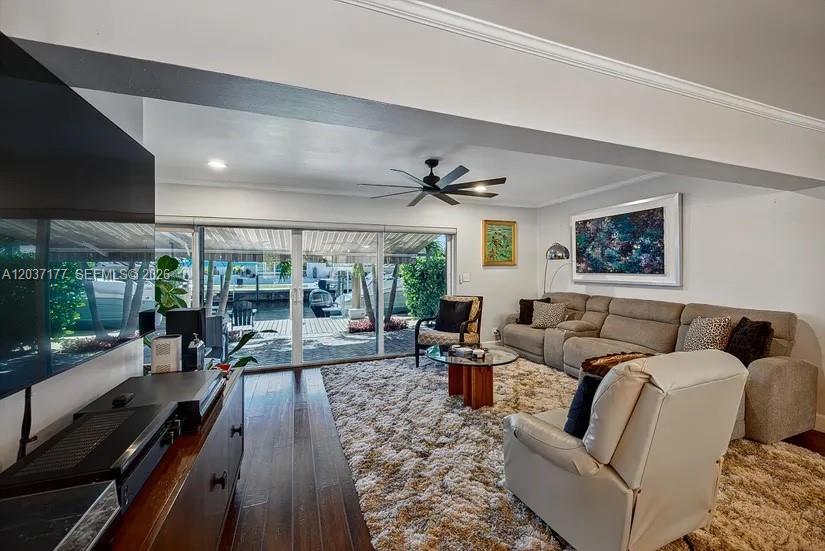 A swimming pool sits in front of a white house with a patio and umbrella — 2125 NE 17th Ter, Wilton Manors FL 33305, WILTON MANORS, FL