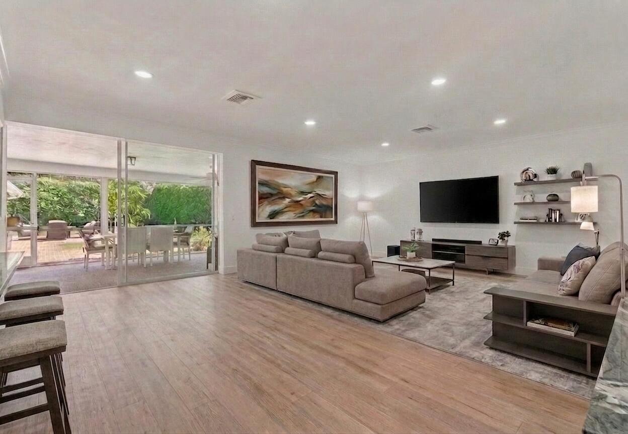 A living room with light wood floors, a sectional sofa, and sliding doors to a patio — 2001 NW 1st Avenue, Delray Beach FL 33444, DELRAY BEACH, FL