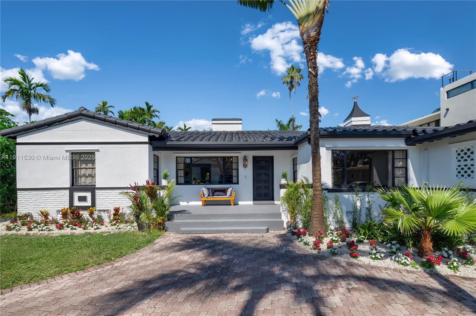 A white single-story house with a dark tile roof and a brick-paved driveway — 118 E 3rd Ct, Miami Beach FL 33139, MIAMI BEACH, FL