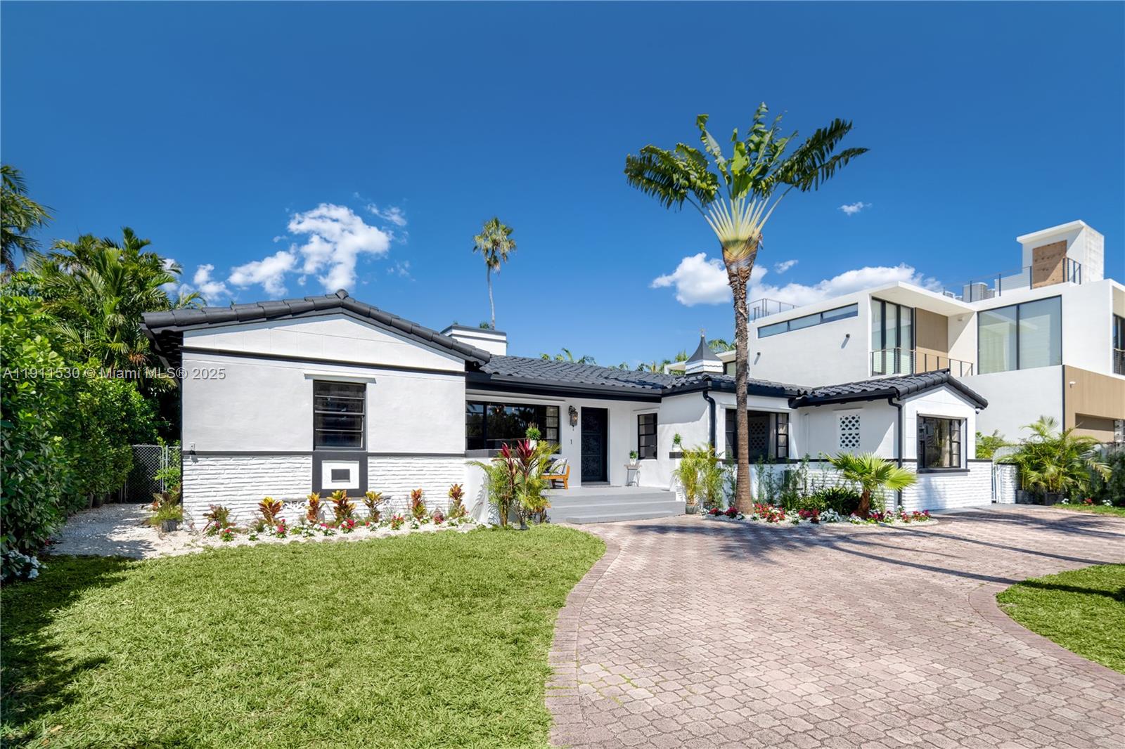 A white, single-story house with a dark roof and a modern two-story addition behind it — 118 E 3rd Ct, Miami Beach FL 33139, MIAMI BEACH, FL