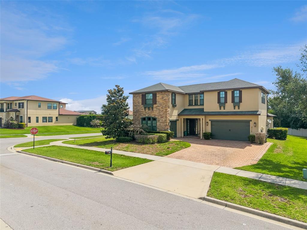 A two-story house with a stone facade, a brick driveway, and a two-car garage — 4117 FOXHOUND DRIVE, CLERMONT, FL