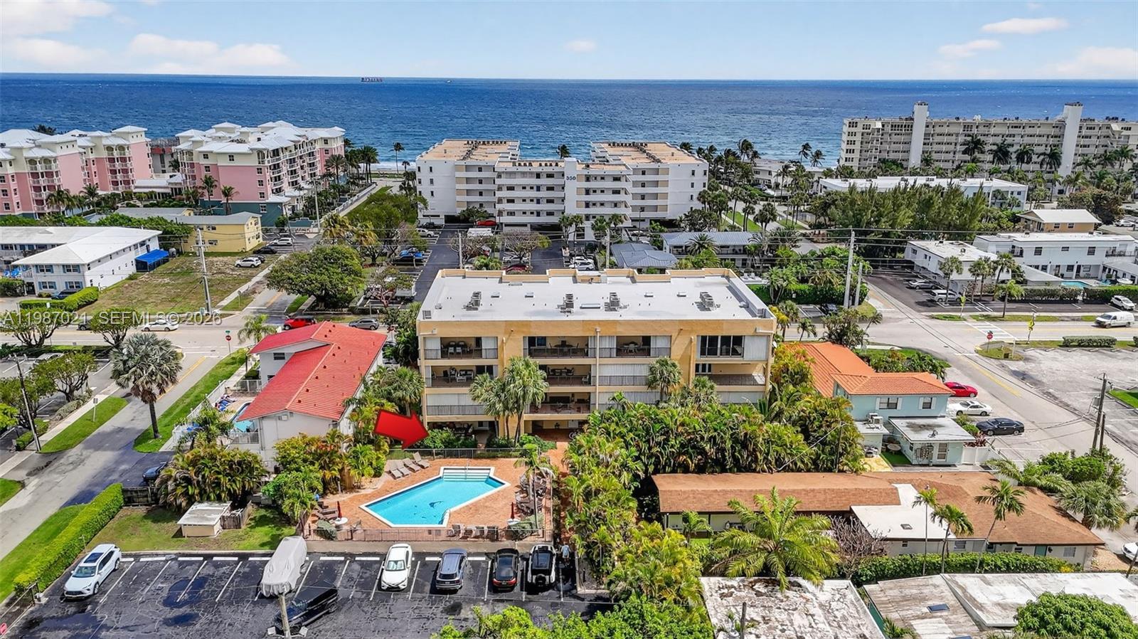 An aerial view shows a multi-story apartment building with a pool and parking lot — 333 SE 20th Ave, Deerfield Beach FL 33441, DEERFIELD BEACH, FL