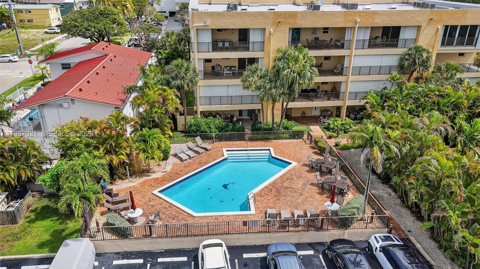 An aerial view shows a swimming pool with a brick deck next to an apartment building — 333 SE 20th Ave, Deerfield Beach FL 33441, DEERFIELD BEACH, FL