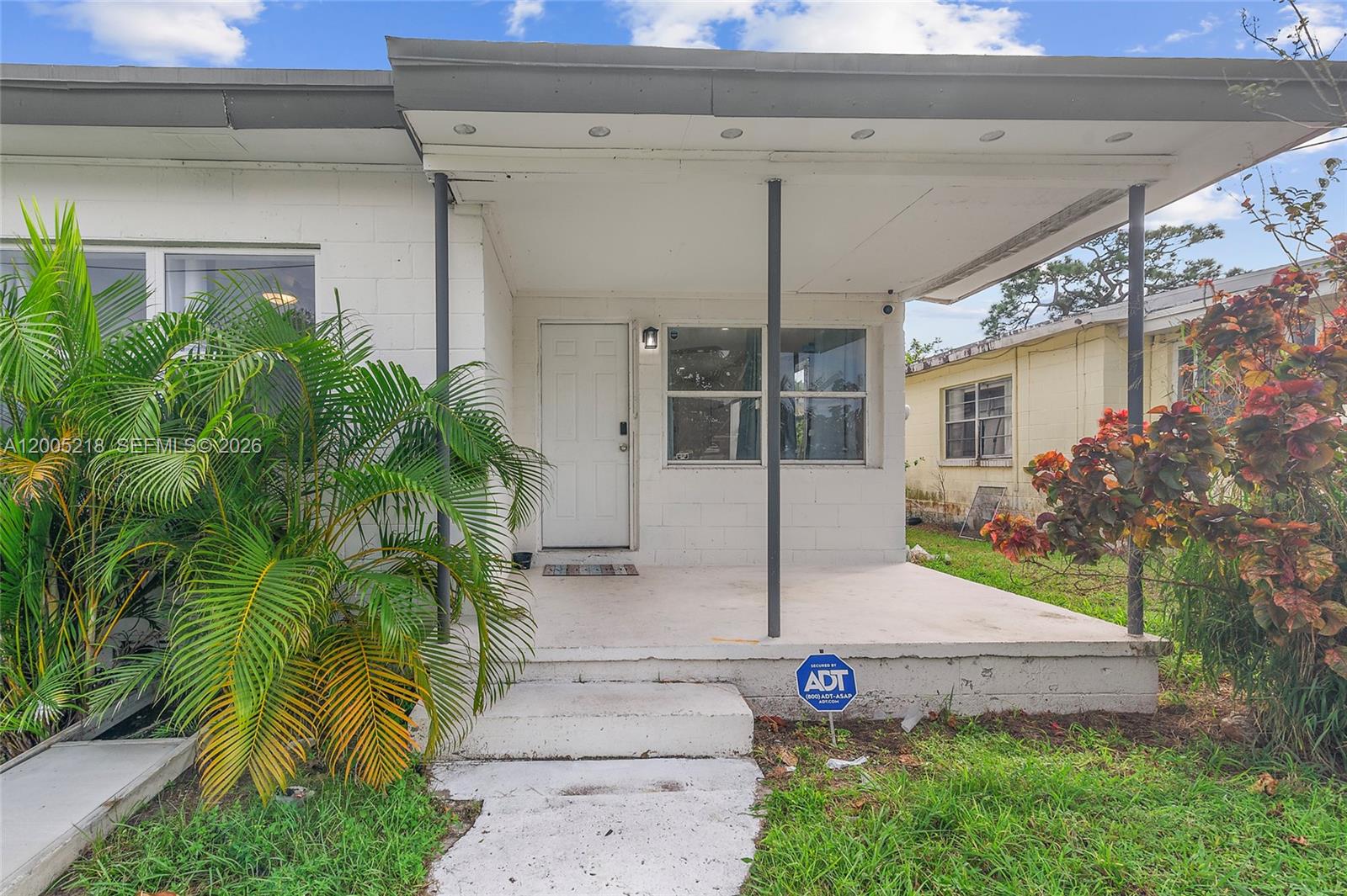 A white concrete block house features a covered front porch with two support pillars — 1408 N 23rd St # 0, Fort Pierce FL 34950, FORT PIERCE, FL