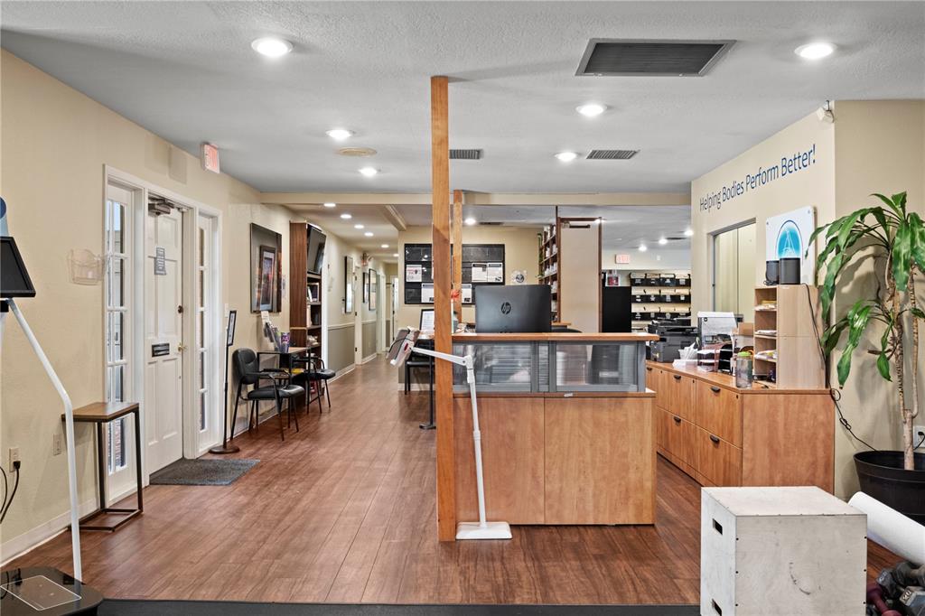 A reception area features a wooden desk, wood-look flooring, and a sign on the wall — 1700 DR MARTIN LUTHER KING JR STREET N UNIT A, ST PETERSBURG, FL