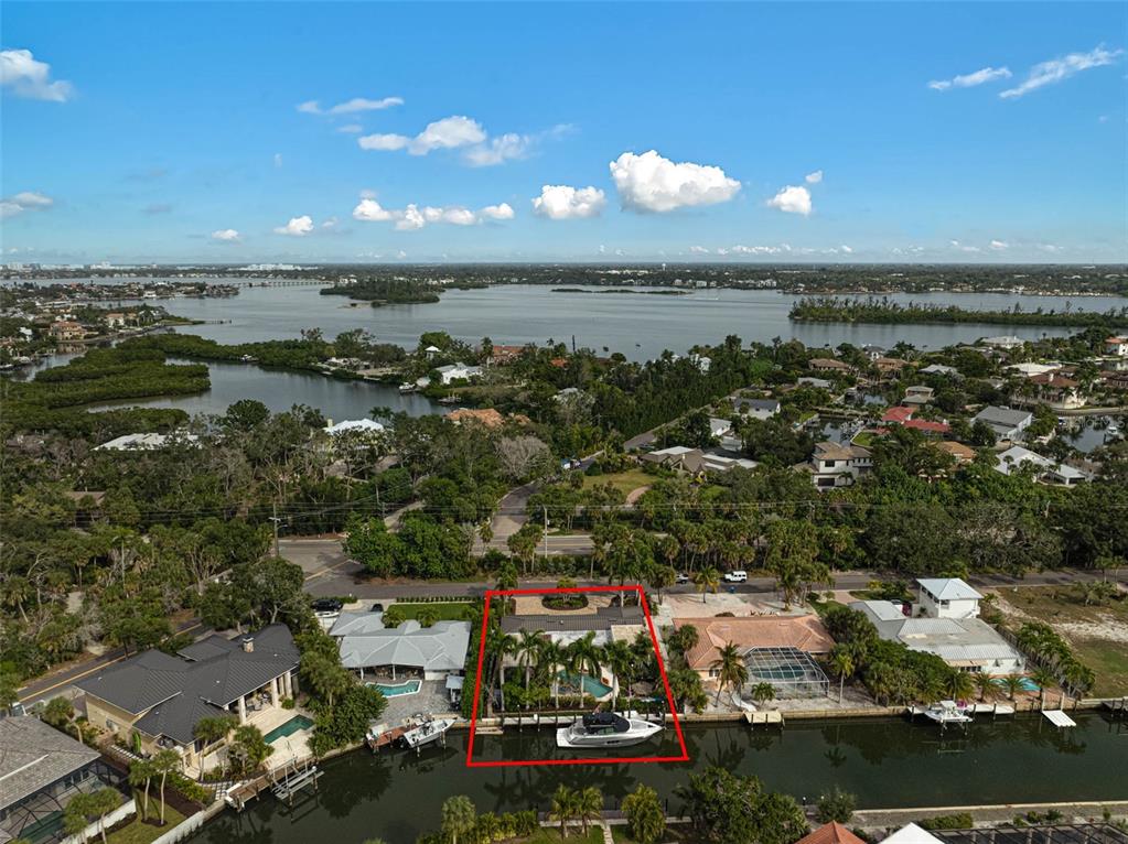 An aerial view shows a waterfront house with a pool and boat dock — 4508 WOODSIDE ROAD, SARASOTA, FL