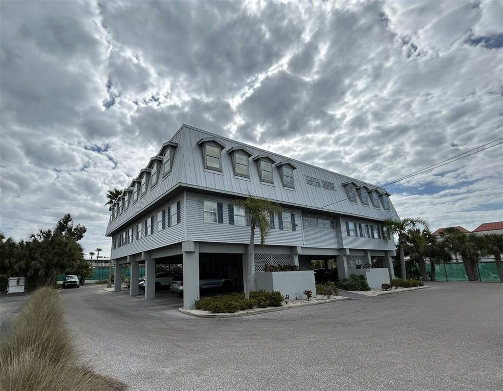 A three-story building with elevated parking underneath and a metal roof — 3909 E BAY DRIVE UNIT 4, HOLMES BEACH, FL