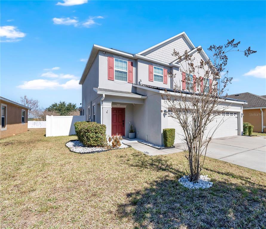 A two-story house with a red front door, red shutters, and a two-car garage — 643 WASHINGTON WAY, HAINES CITY, FL