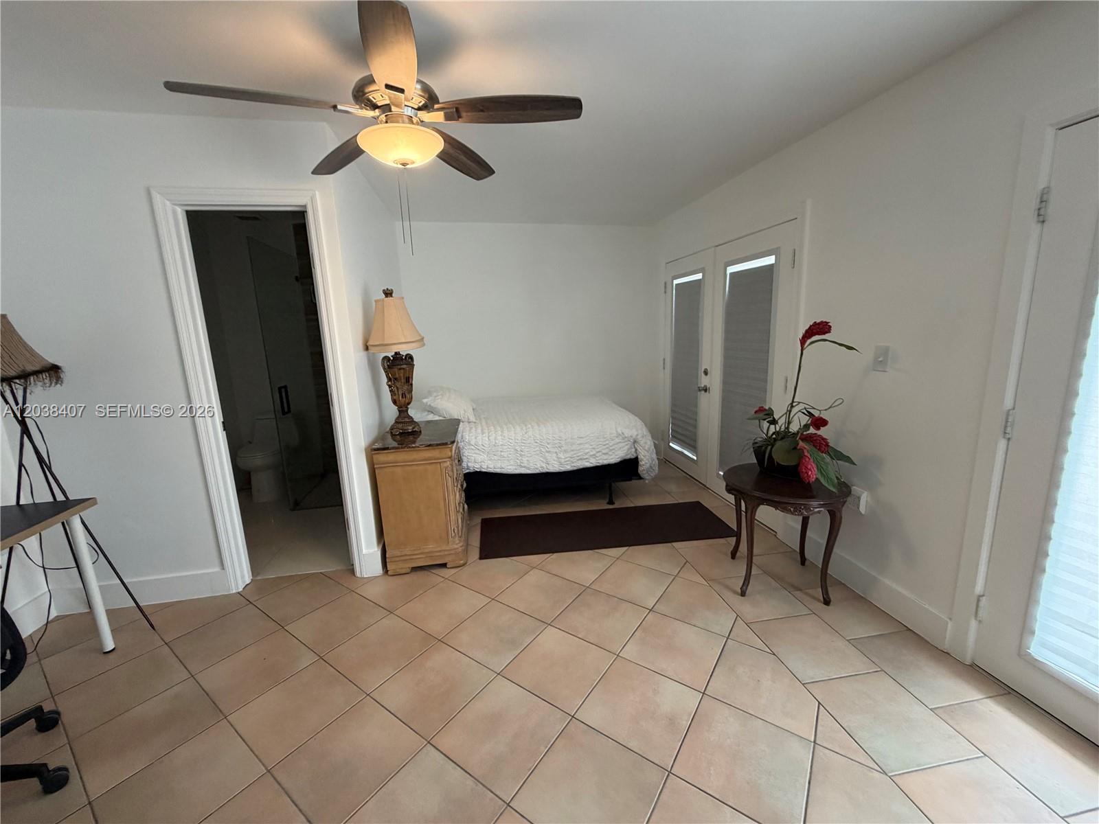 A bedroom features tile flooring, a ceiling fan, a bed, and a doorway to a bathroom — 5931 SW 148th Pl # 1, Miami FL 33193, MIAMI, FL