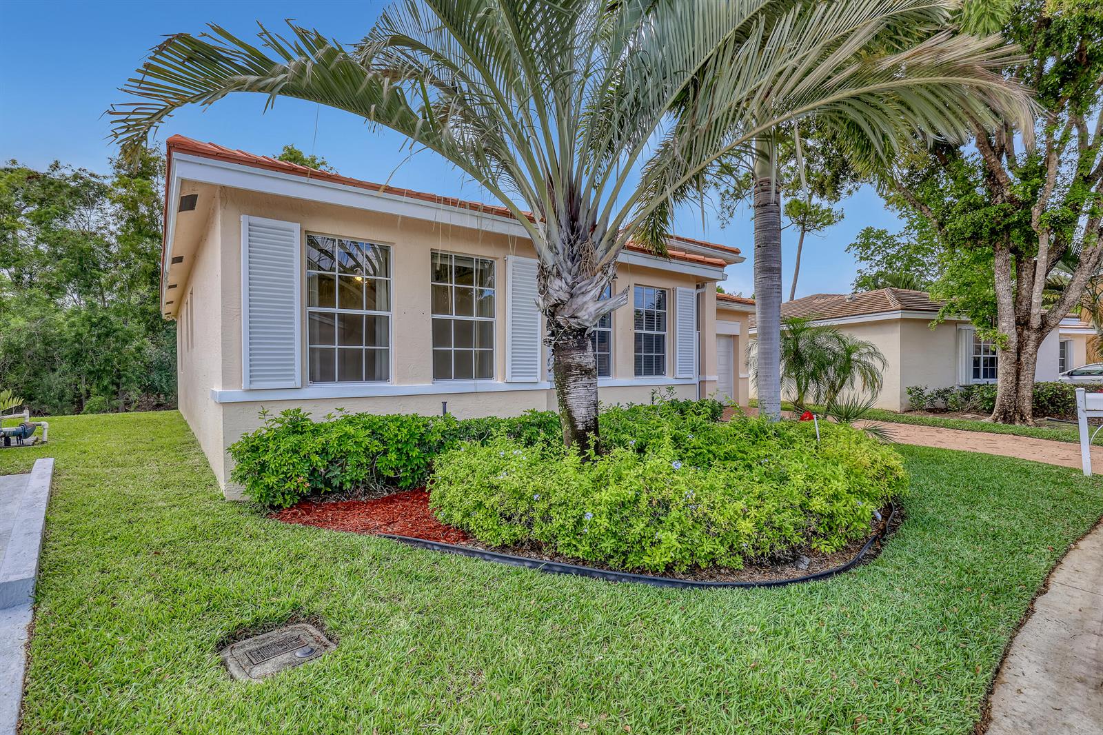 A single-story house with a palm tree in the front yard and a green lawn — 180 Caribe Court, FL 33413, FL