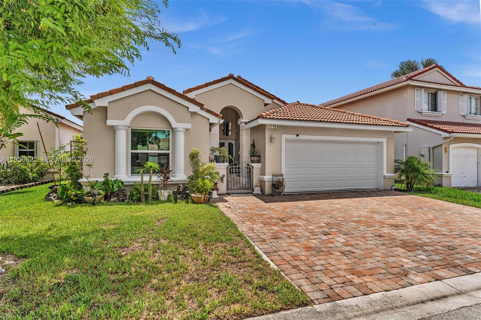 A single-story house with a beige stucco exterior, a tiled roof, and a brick driveway — 3388 SW 49th St, Hollywood FL 33312, HOLLYWOOD, FL