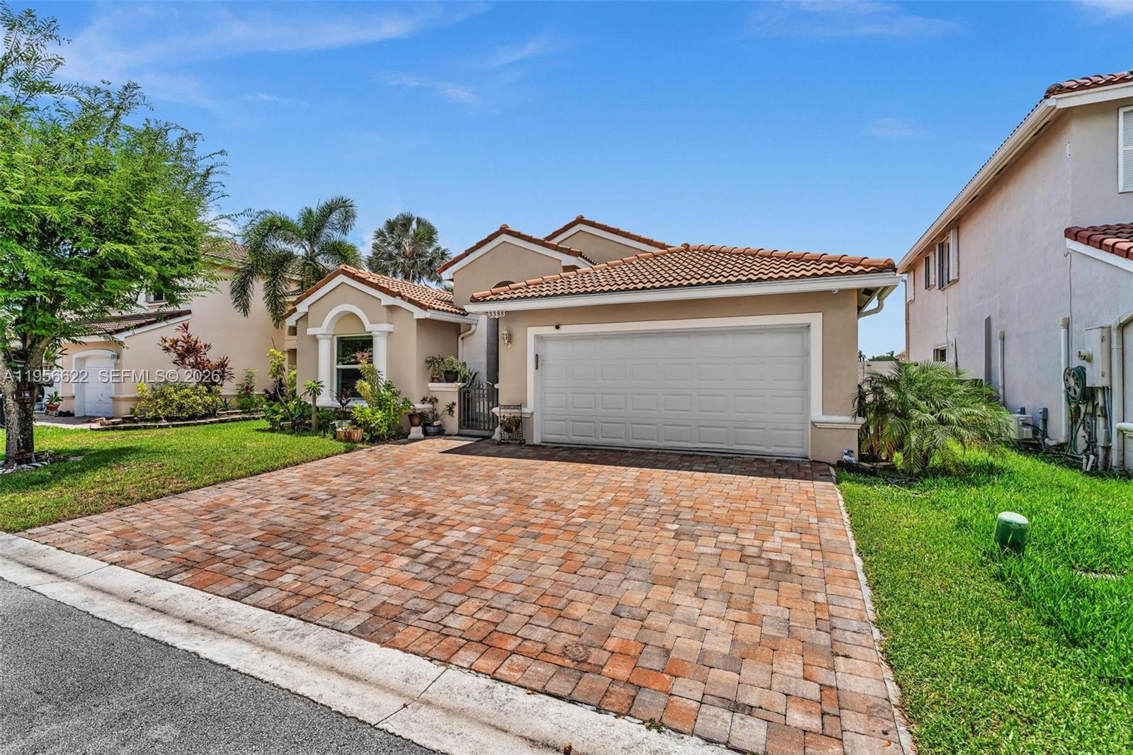 A single-story house with a tiled roof, a brick paver driveway, and a two-car garage — 3388 SW 49th St, Hollywood FL 33312, HOLLYWOOD, FL